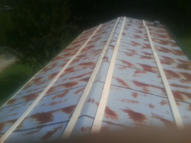 Rusted metal roof panels with new wood purlins before replacement — Storm Damage Roof Repair in Owego by Roofing Brothers