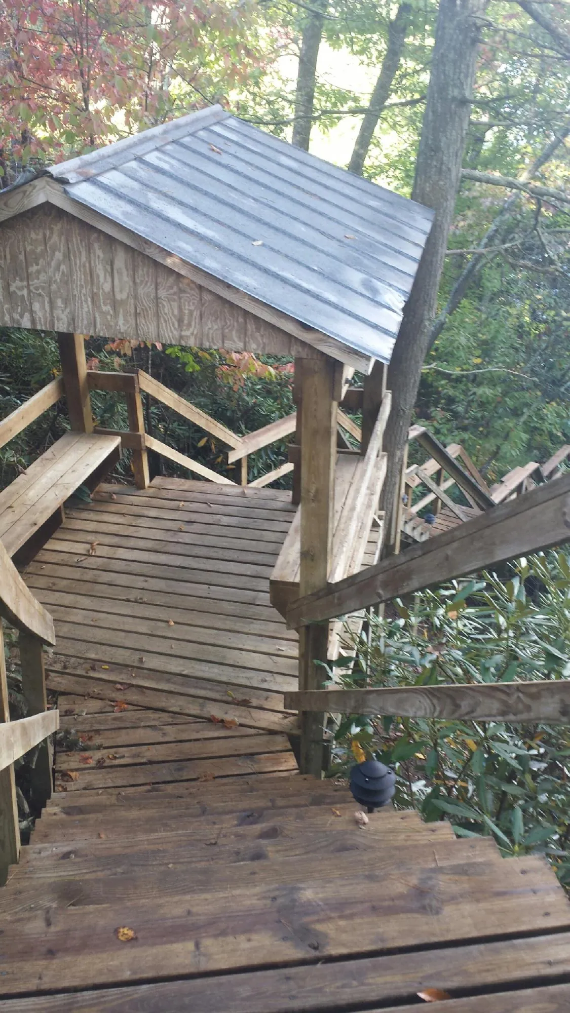 Metal roofed shelter over wooden steps on a wooded walkway — Skylight Repair & Installation work by our crew in Owego