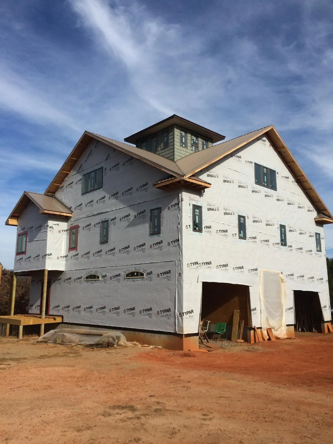 New two story house under construction with a cupola and gabled roofs in Owego
